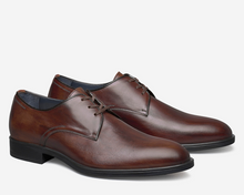 Pair of brown dress shoes on a light gray background