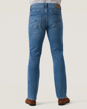 Back side of blue jeans worn by a person on a white background