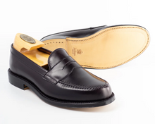 Burgundy loafer shoe with beige interior on a white background