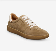 Beige sneaker with white laces on a light gray background