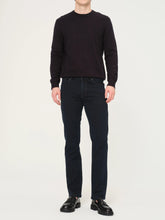 Person wearing a black sweater and black jeans on a white background