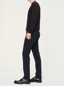 Person wearing a black sweater and dark pants on a white background