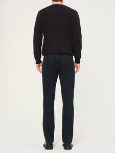 Person wearing a black sweater and dark jeans on a white background