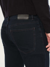 Dark jeans with a brand label on a white background