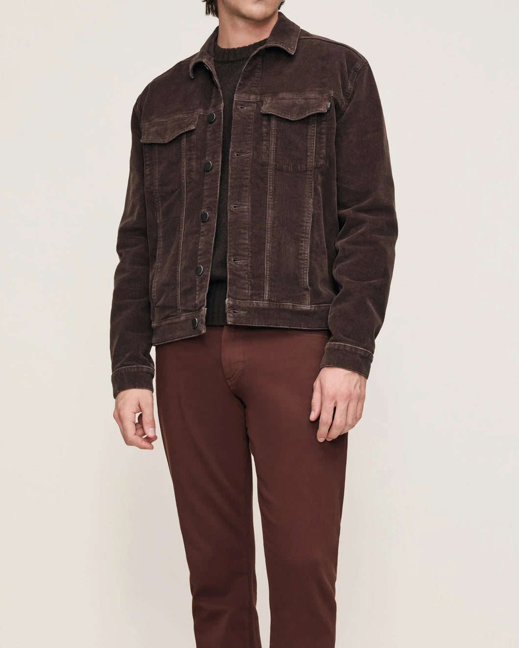 Person wearing a brown jacket and pants on a white background