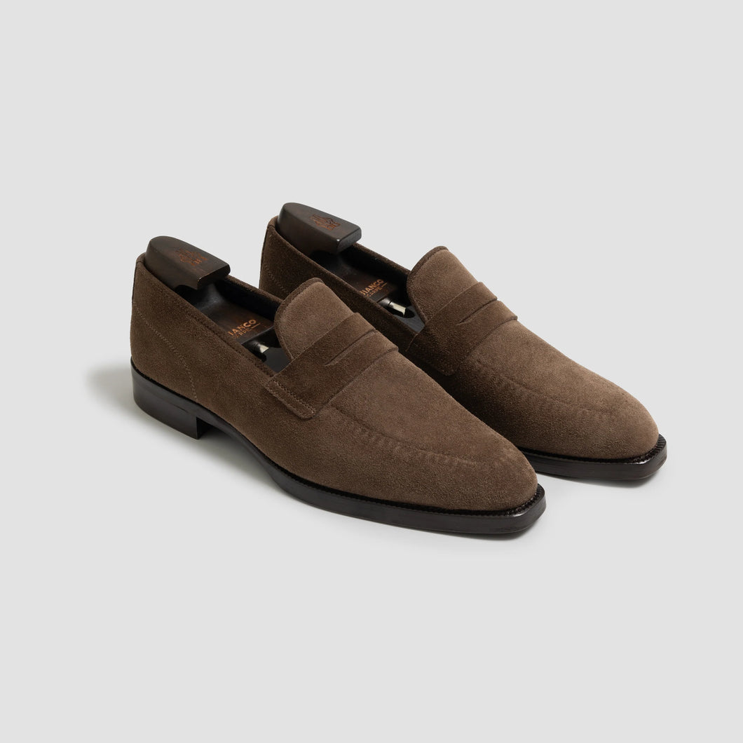 Pair of brown loafers on a light gray background
