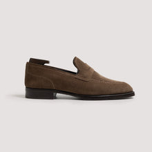 Brown loafer shoe on a light gray background