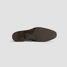 Brown leather shoe sole on a light gray background