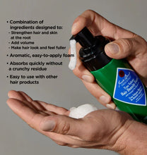 Hand holding a green bottle of hair product with text detailing its benefits on a gray background
