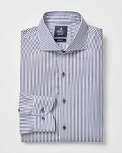 Folded striped dress shirt with a brand label on a light gray background