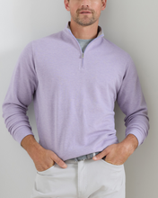 Man wearing a light purple quarter-zip sweater against a plain background