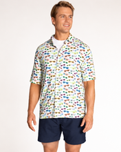man in navy shorts and sunglass print shirt