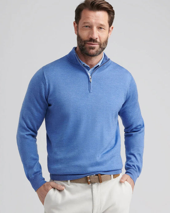 Man wearing a blue pullover with a zipper on a gray background