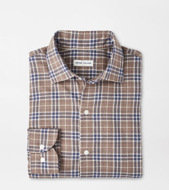 Folded plaid shirt with 'Peter Millar' label on a light gray background