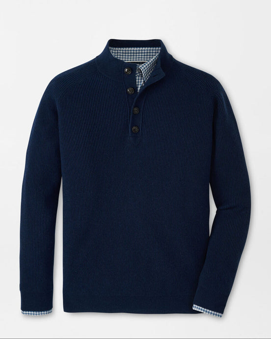 Navy blue sweater with button details on a light gray background