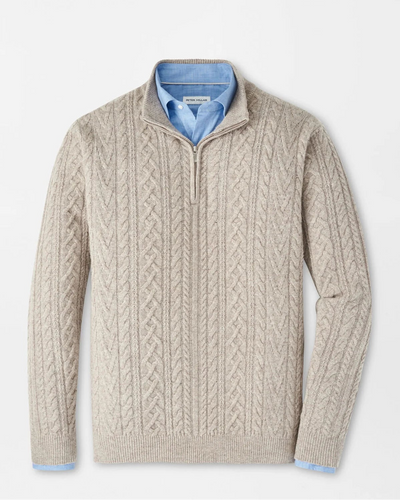 Beige cable knit sweater with blue shirt collar on a light gray background