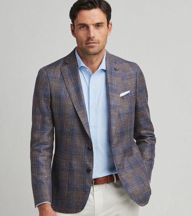 Man wearing a plaid blazer over a light blue shirt with a gray background