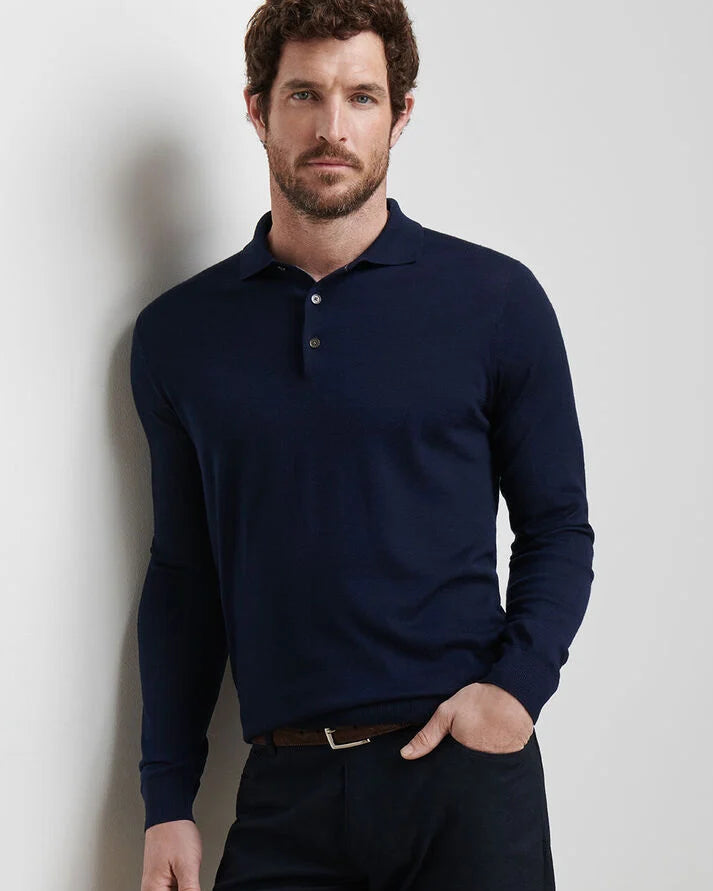 Man wearing a navy long-sleeve polo shirt against a light gray background