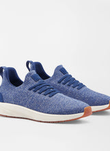 Blue sneakers with white soles on a light gray background