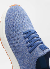 Blue textured sneaker with white sole on a light gray background