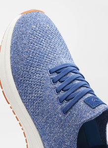 Blue textured sneaker with white sole on a light gray background