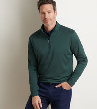 Man wearing a green pullover with a blurred background