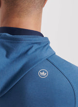 Close-up of a blue hoodie with a logo on a plain background