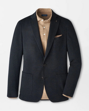 Dark blazer over a beige shirt with a pocket square on a light gray background