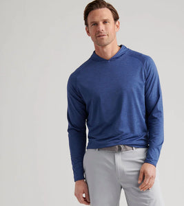 Man wearing a blue long-sleeve shirt and light gray pants on a white background