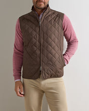 man in pink sweater and brown quilted vest
