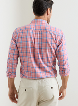 Man wearing a red and blue plaid shirt against a white background