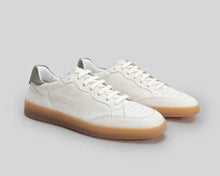 White sneakers with brown soles on a light gray background