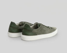 Pair of green sneakers on a light gray background