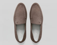 Pair of brown suede loafers on a light gray background