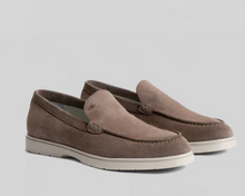 Pair of brown loafers on a light gray background