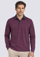 A man wearing a long-sleeve polo shirt in heathered purple with a contrasting dark navy collar, paired with beige trousers, against a plain white background.
