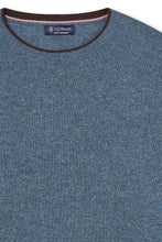 Close up of Turtleson's blue crew neck cashmere sweater with brown rim around collar