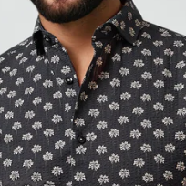 Man wearing a black patterned shirt against a white background