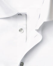 Close-up of a white polo shirt with buttons on a light gray background