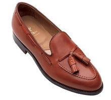 A brown calfskin tassle loafer with a single oak leather outsole, displayed against a white background.