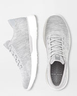 White sneakers with a textured knit design on a light gray background